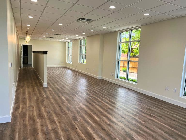 Open office area with wood look flooring and large windows at 1045 East 3900 South in Millcreek