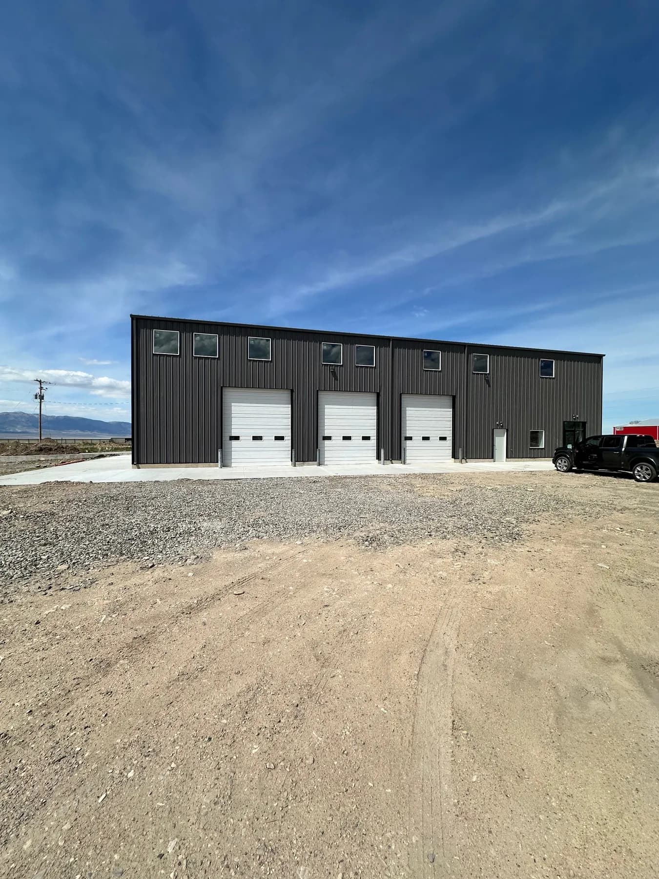 Three grade level roll up doors facing the yard at 1161 W Utah Ave, Tooele